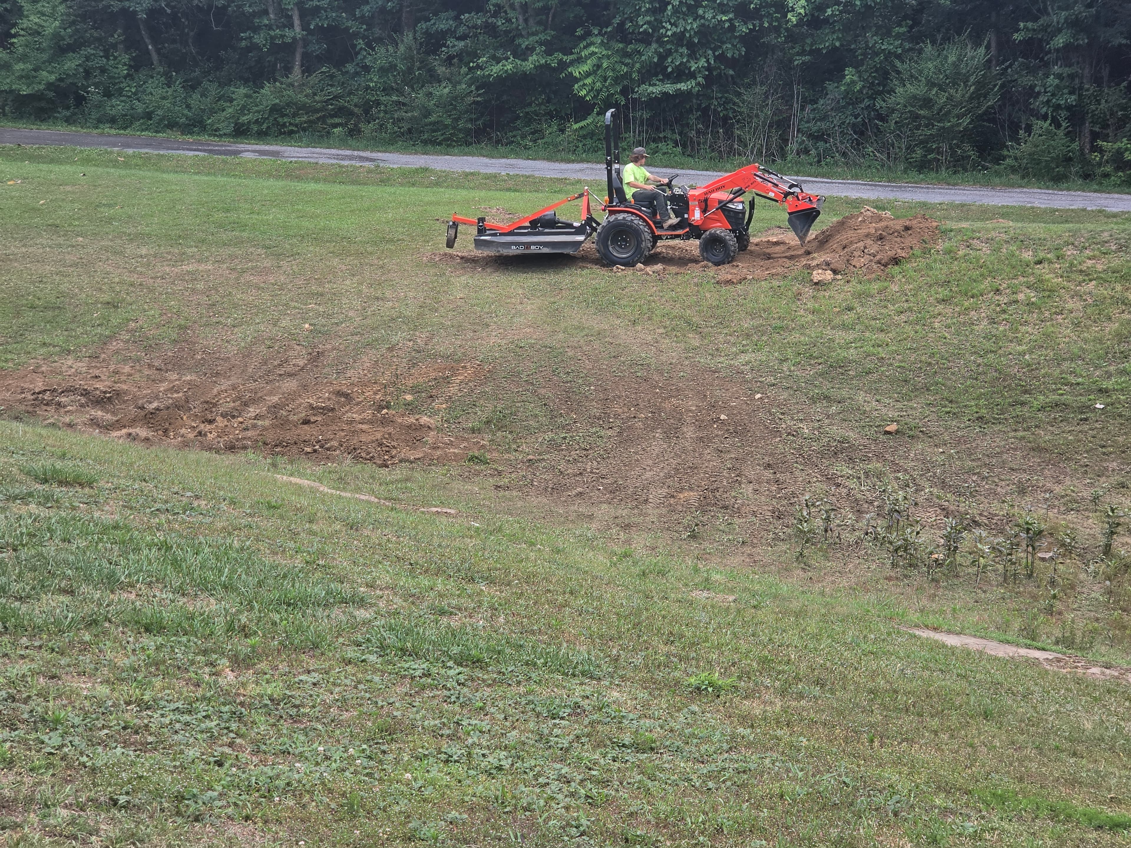 Compact tractor doing earthwork on a back lot