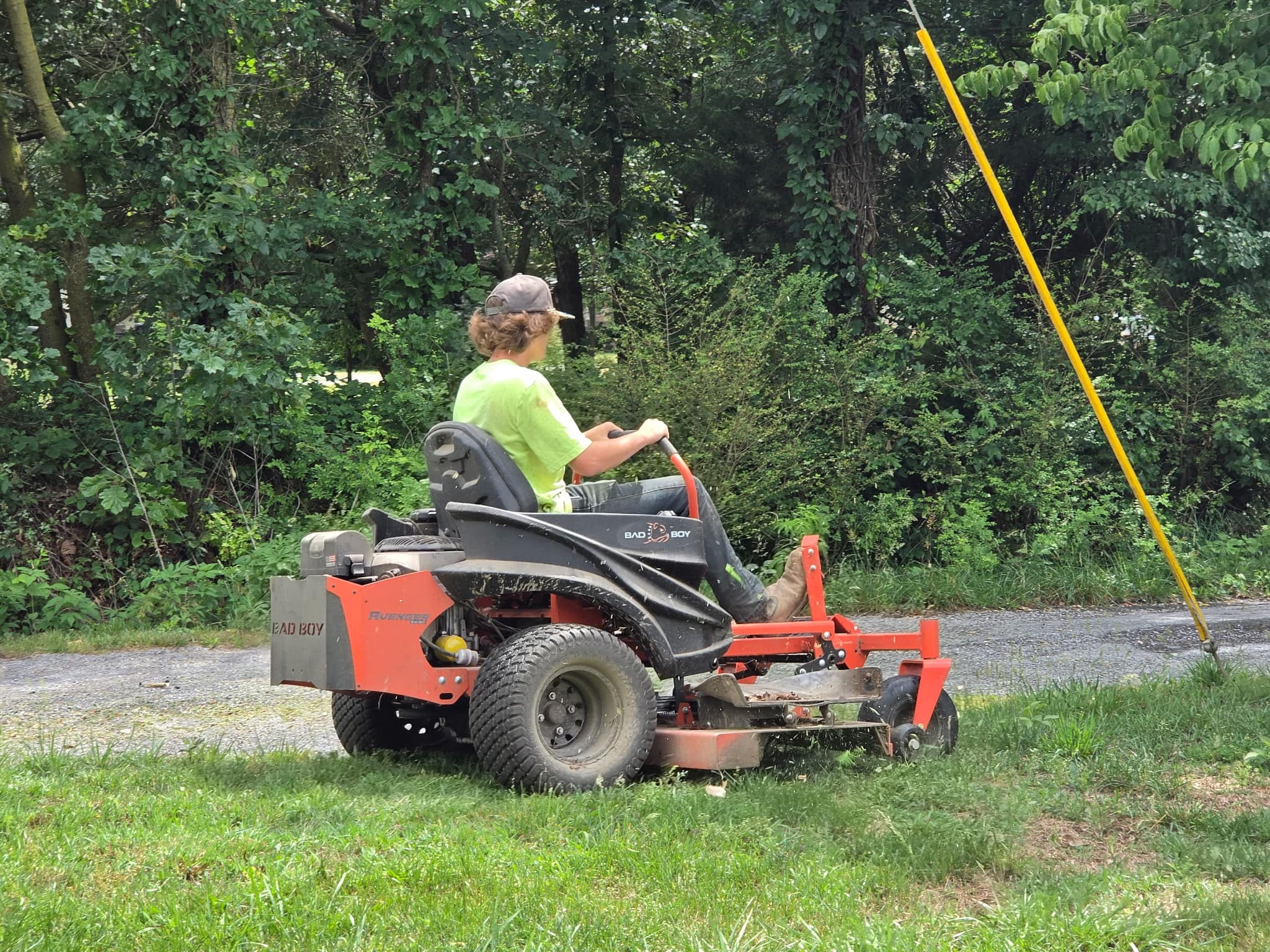 Roger Reed on a commercial zero-turn mower cutting a fenceline